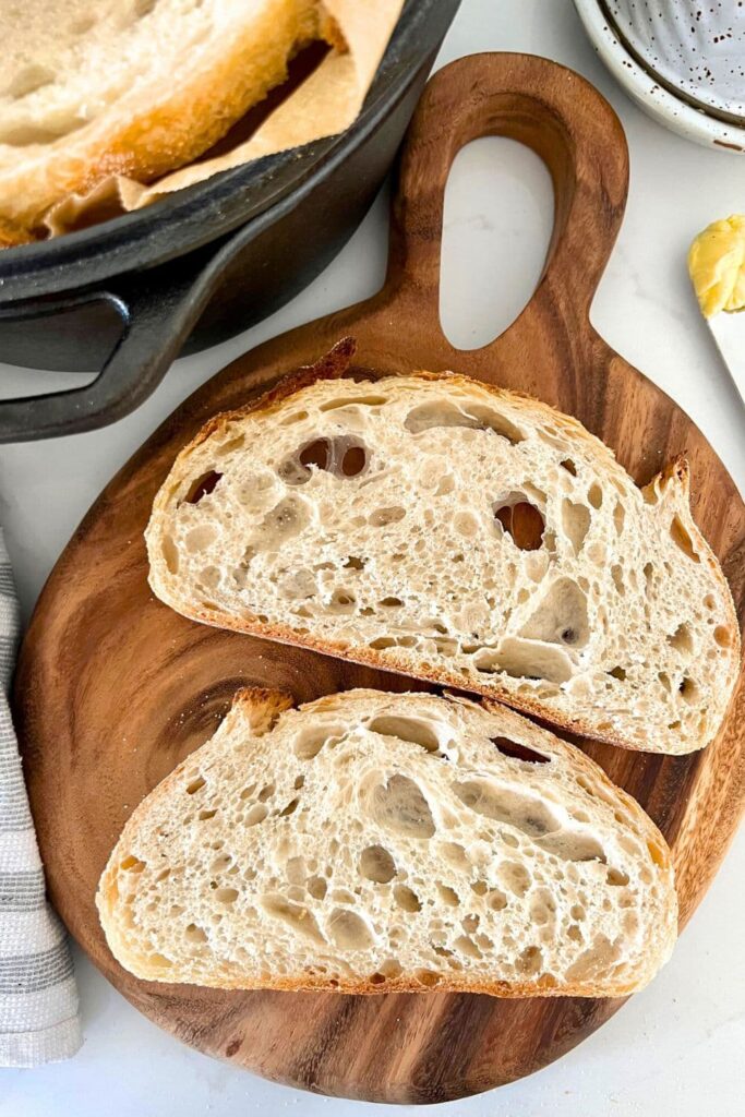 Sourdough glossary - photo shows two slices of sourdough bread arranged on a wooden board to show the alveoli or air pockets inside the bread.