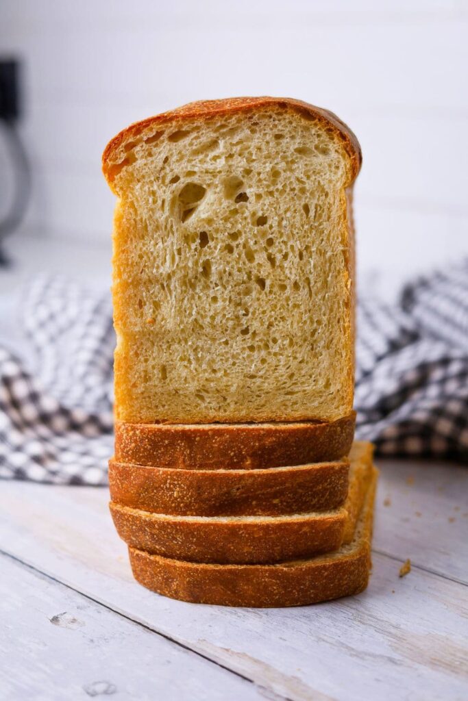 Sourdough sandwich loaf that has been sliced and displayed so you can see the soft crumb inside. 