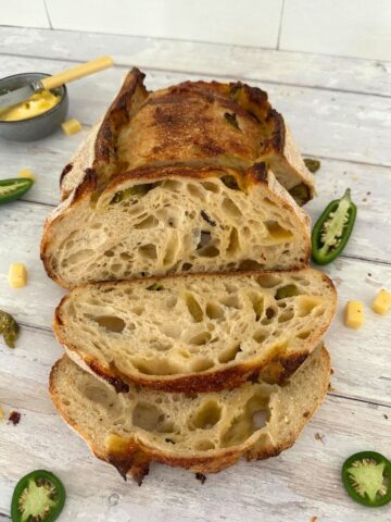 Jalapeno Cheddar sourdough bread that has been sliced open so you can see the open crumb inside.