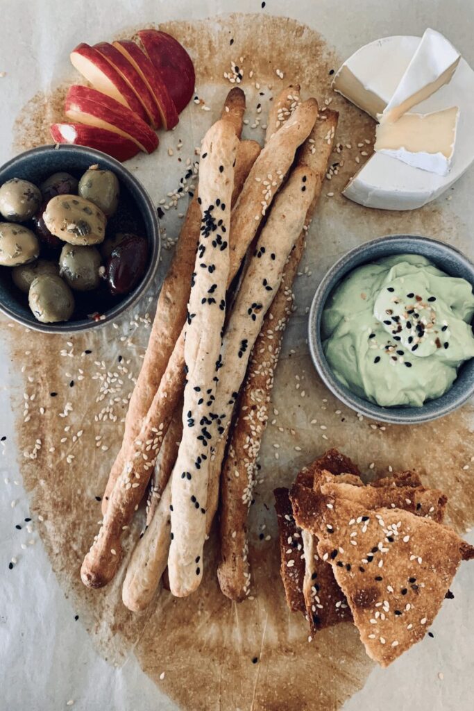 A charcuterie platter with the best sourdough cracker recipes - sourdough grissini and sourdough lavosh.