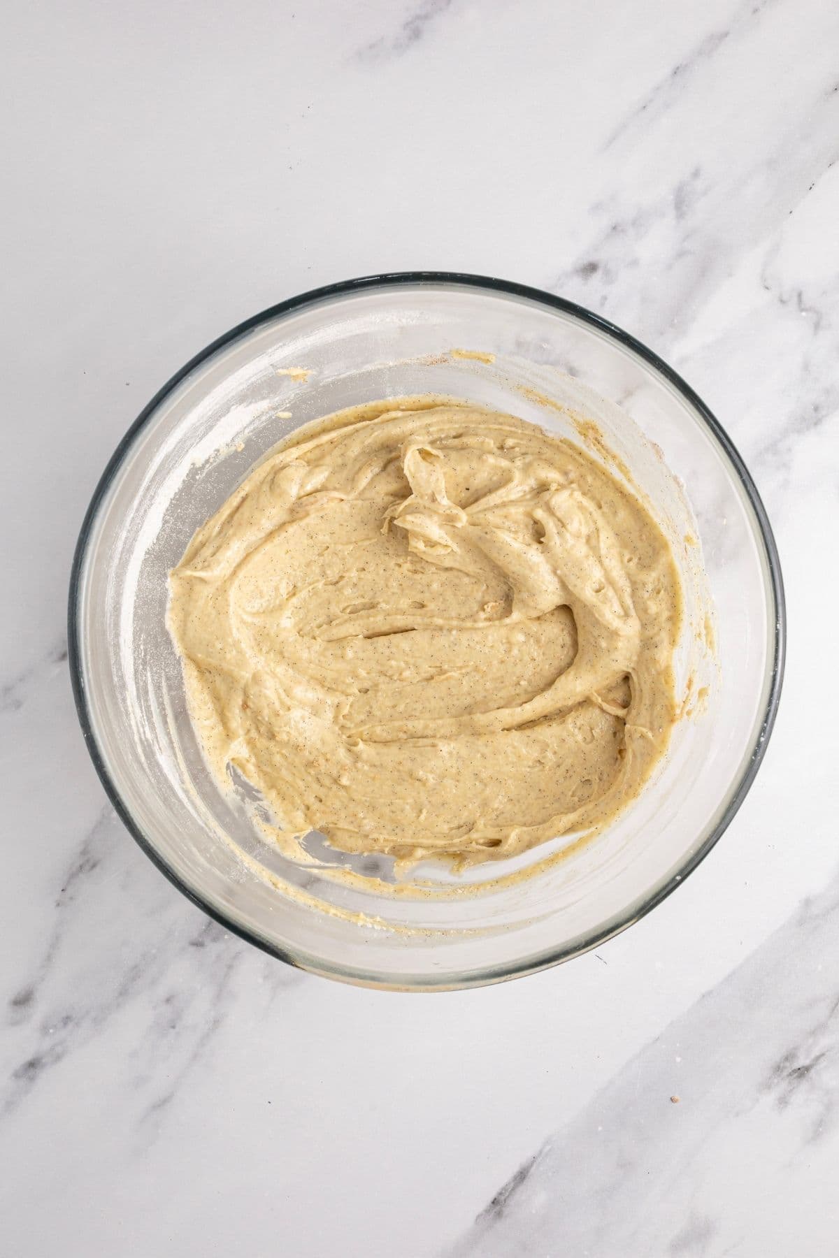 The cake batter for sourdough apple cake mixed in a glass mixing bowl.