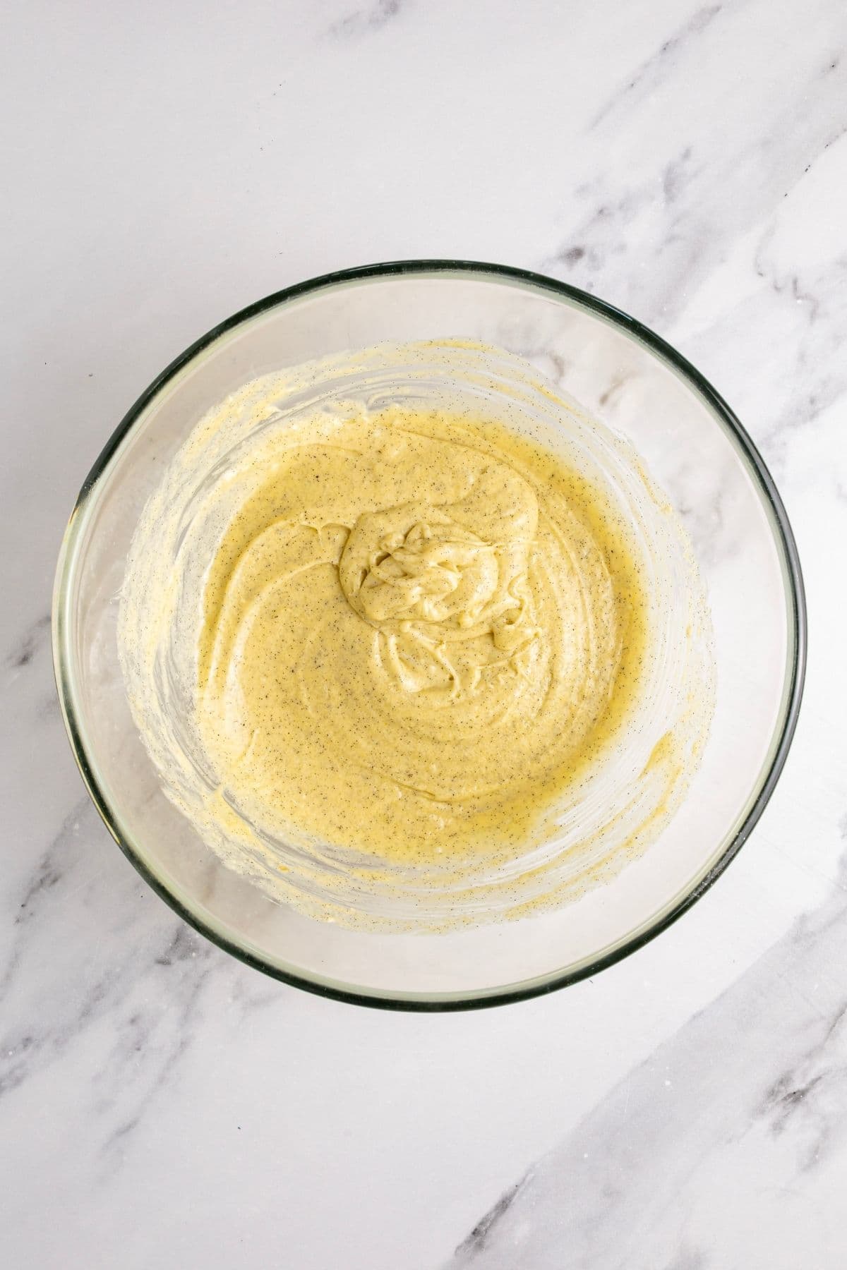 Liquid ingredients whisked together in a glass bowl.