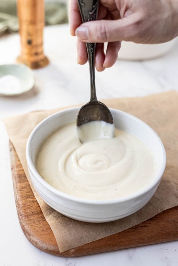 Sourdough Bechamel Sauce served in a white bowl with a vintage spoon.