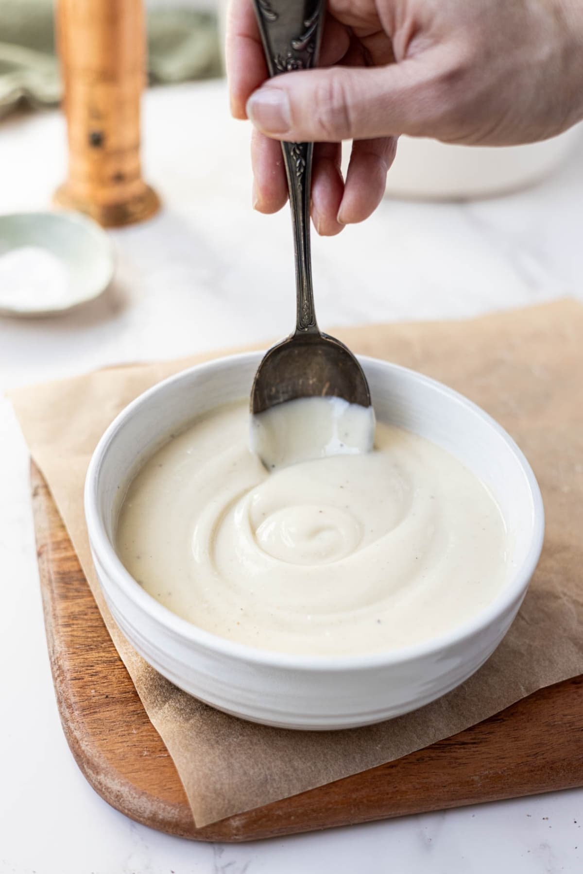 Sourdough Bechamel Sauce served in a white bowl with a vintage spoon.