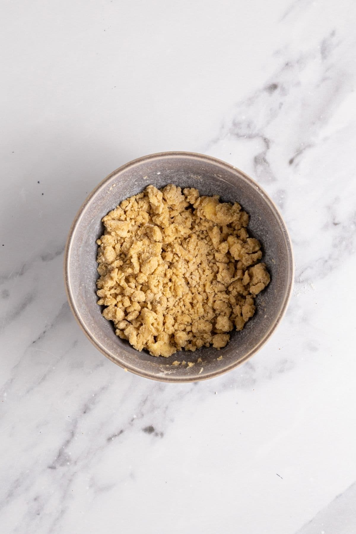 A small grey bowl of the streusel topping.
