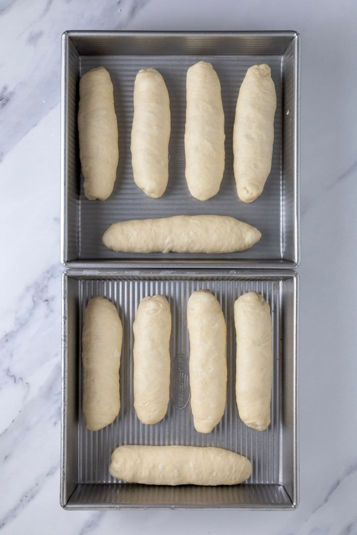 2 USA Pan Square Pans with 5 sourdough hot dog buns in each. This photo is right after shaping so the buns are not touching each other.