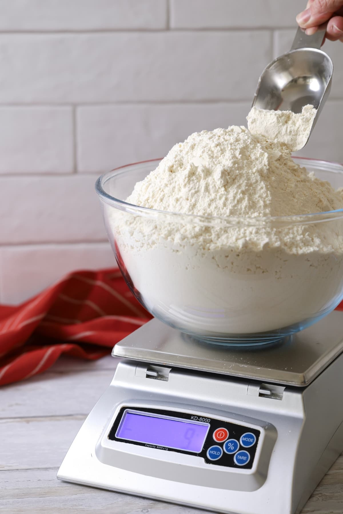 Best flour for sourdough bread - a digital kitchen scale holding a glass bowl full of bread flour.