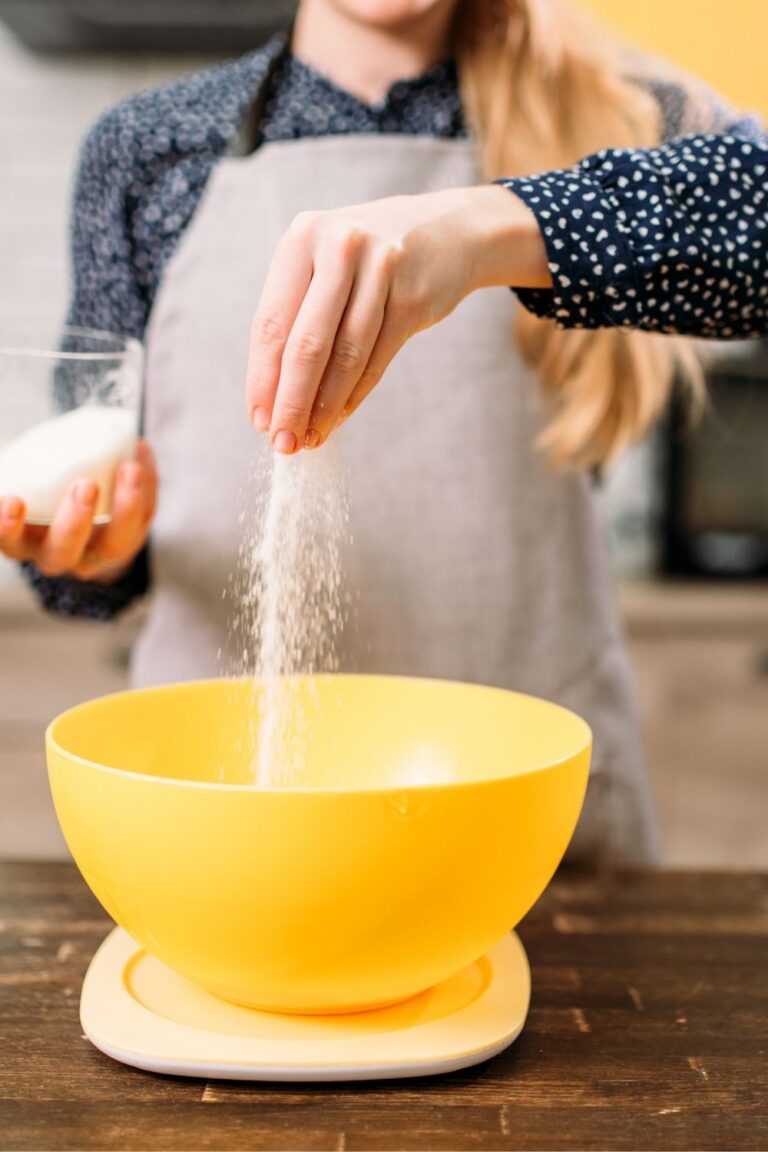 GIRL ADDING SUGAR TO SOURDOUGH BREAD BEING MIXED IN YELLOW BOWL