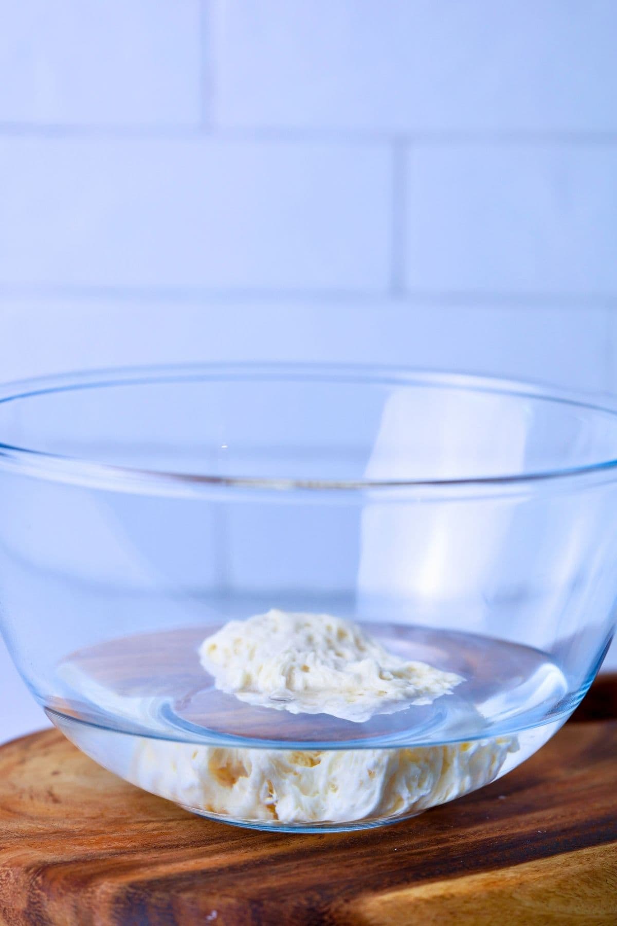 A large scoop of bubbly sourdough starter that has been added to a bowl of water to see whether it floats or not.