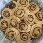 Puffy sourdough cinnamon rolls ready to be baked in the oven.