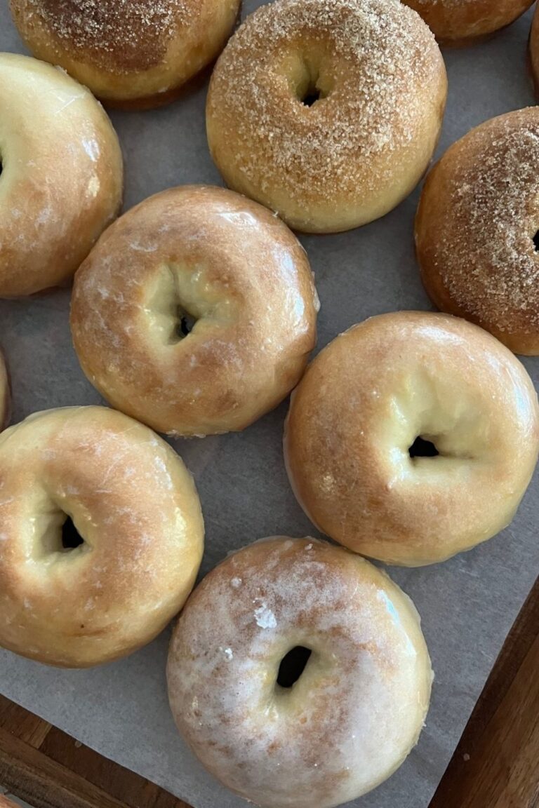 Baked sourdough donuts displayed on a wooden tray