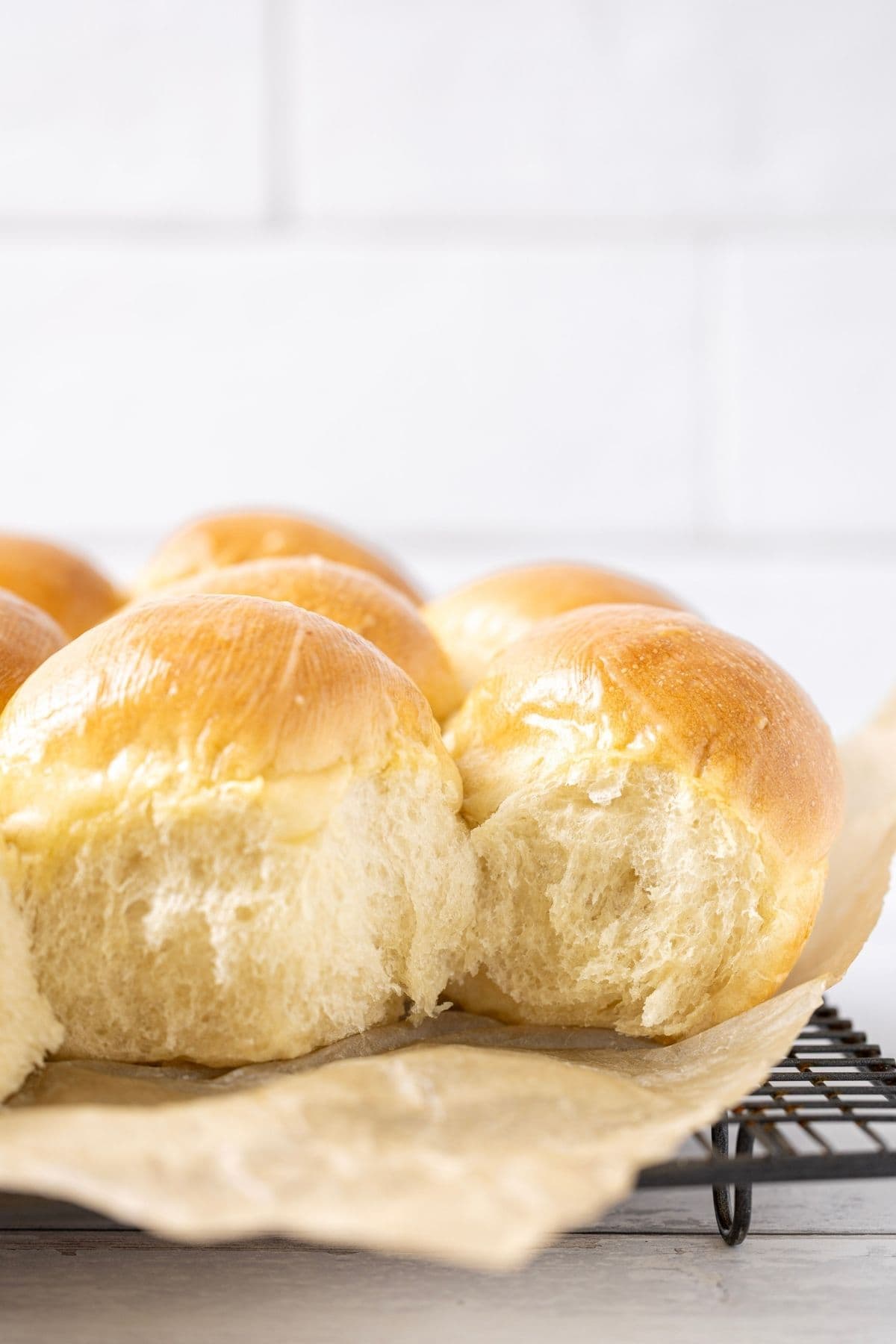 A close up image of sourdough discard rolls showing the soft, fluffy texture inside the rolls.