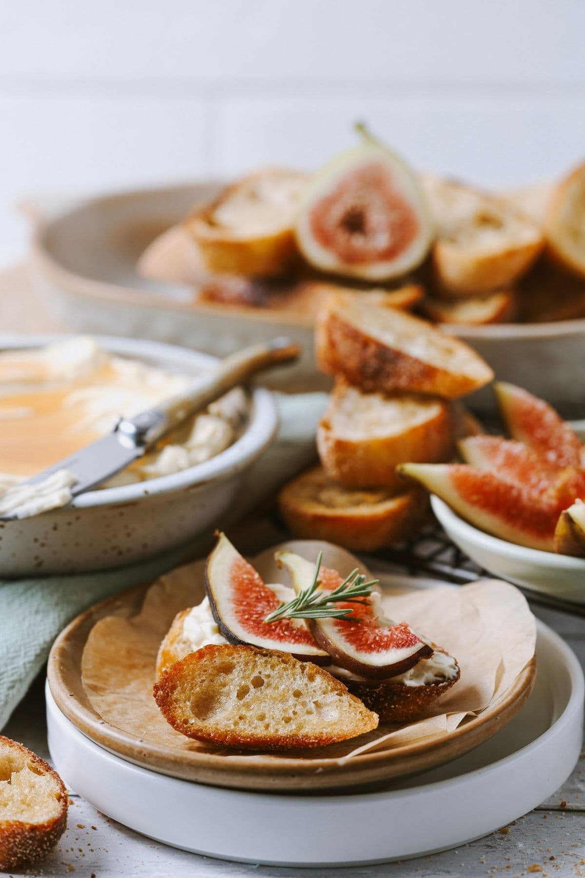 A scene showing two sourdough crostini topped with whipped cream cheese and fresh figs.