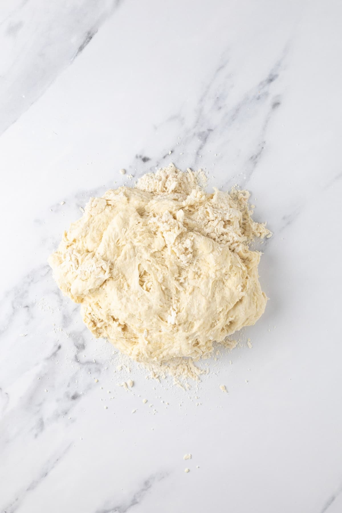 Rough, dry sourdough discard pizza dough just tipped out on the counter ready to knead.
