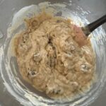 Sourdough chocolate chunk muffin mixture in glass bowl with spatula