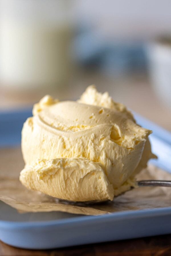 A large scoop of cultured butter placed on a pale blue baking sheet lined with parchment paper.