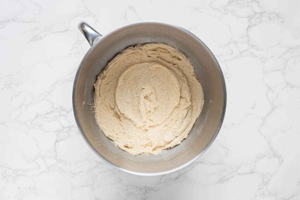 A stainless steel stand mixer bowl containing sourdough snickerdoodle mixture that is ready to be scooped out.