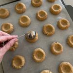 Use a spoon to make an indent in the centre of each cookie dough ball.