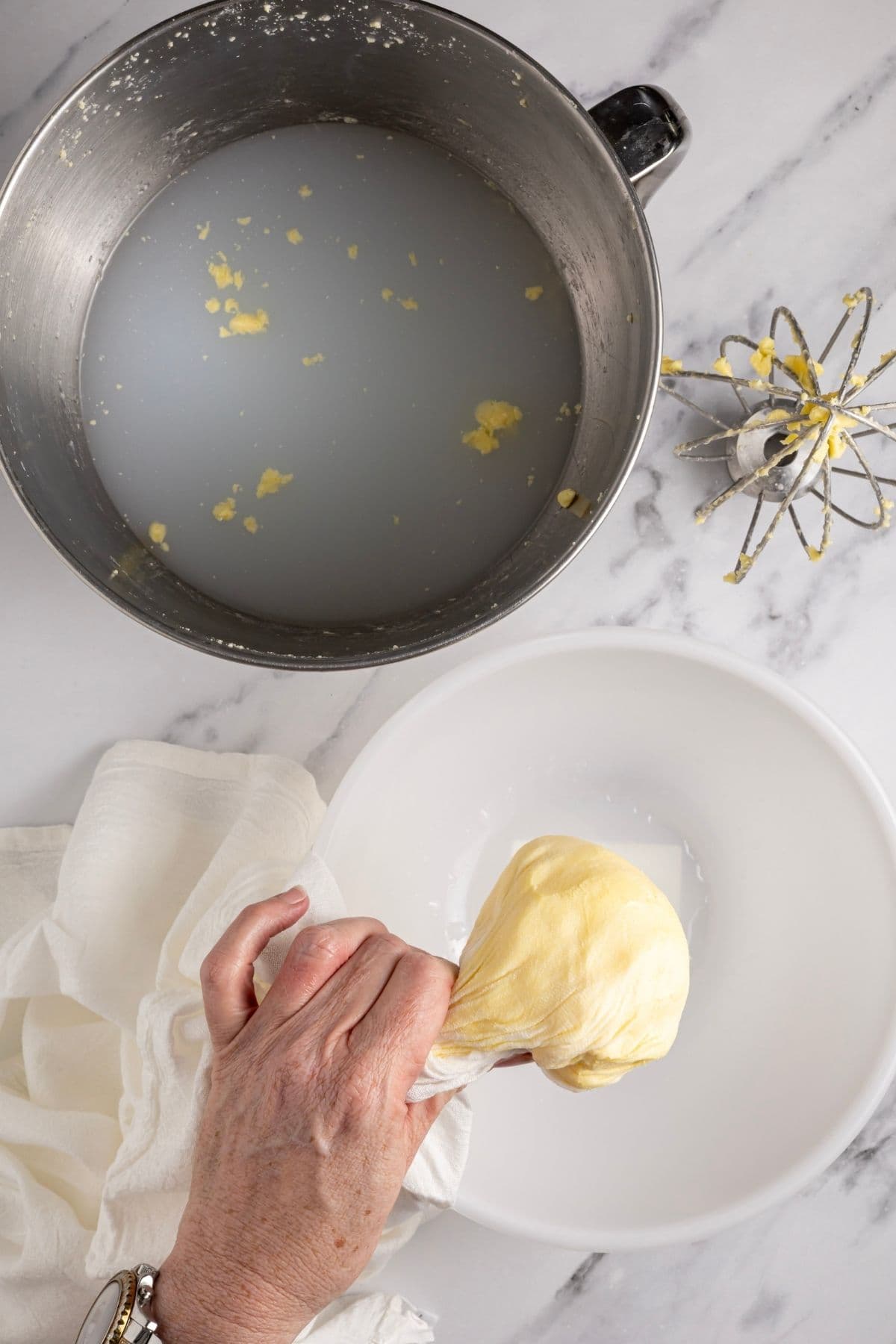 A photo showing the butter being squeezed in some fine cloth to remove all of the buttermilk.