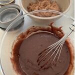 Whisking the sourdough chocolate cake batter with vegetable oil, cocoa, baking soda, baking powder and salt.