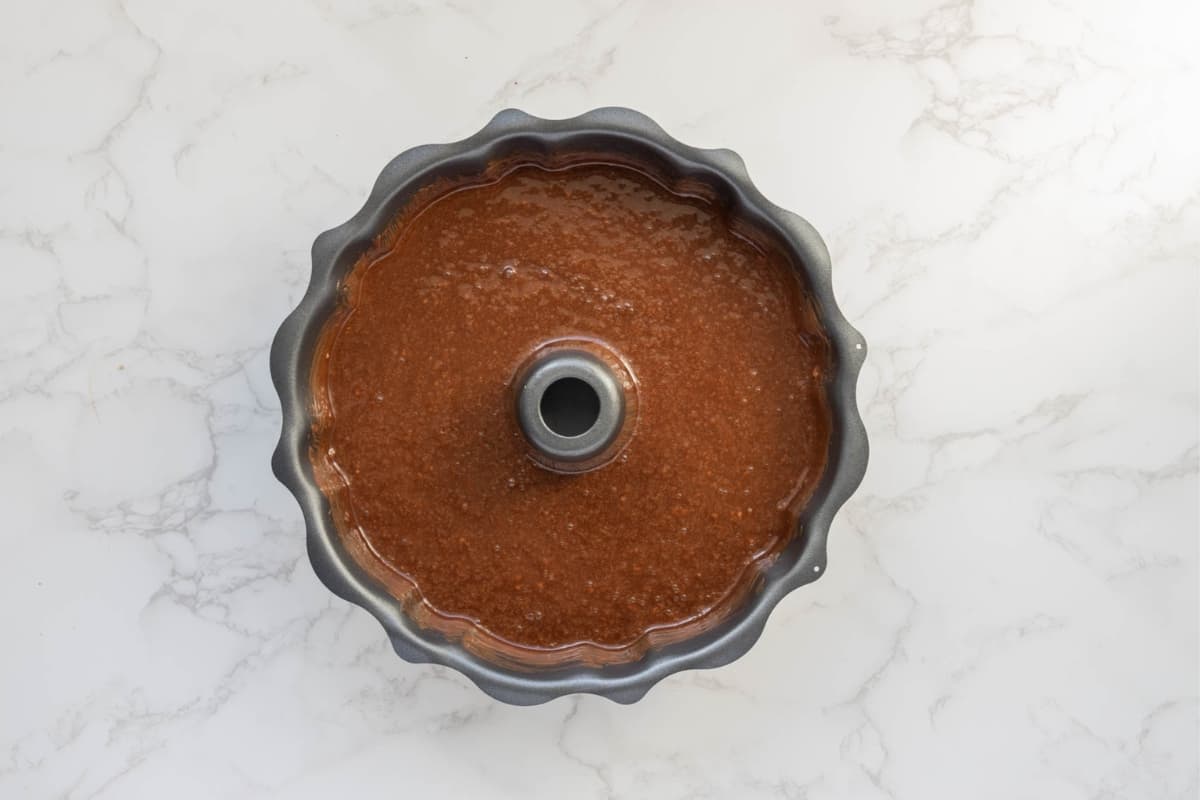 Chocolate sourdough cake batter poured into a greased bundt pan ready for baking.
