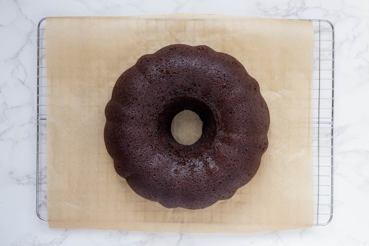 Freshly baked sourdough chocolate bundt cake cooling on a wire rack after being removed from the pan.