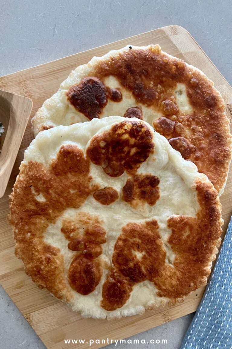 2 pieces of fried sourdough pizza sitting on a pizza peel with a light blue teatowel to the right.