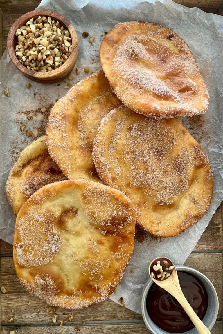 Sourdough Elephant Ears dusted in cinnamon sugar. There is a dish of chocolate sauce and crushed walnuts in the picture too.