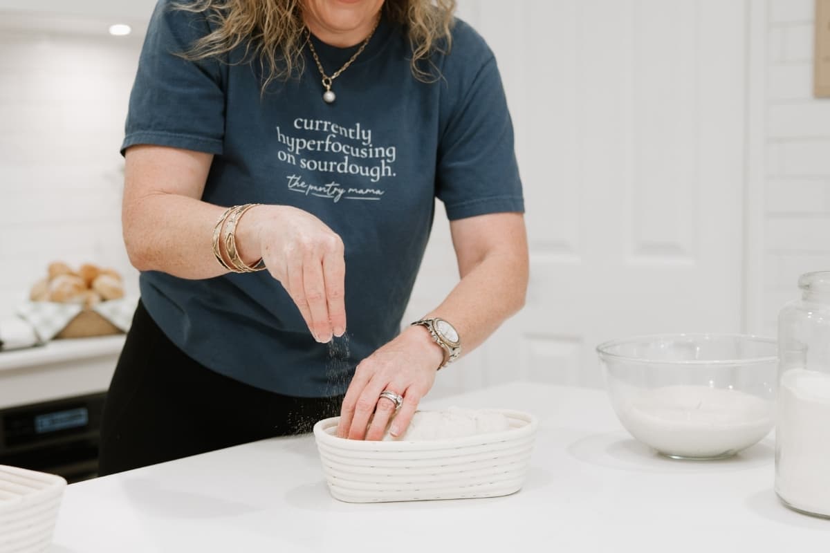 Kate from The Pantry Mama sprinkling semolina into the banneton to stop the dough sticking.
