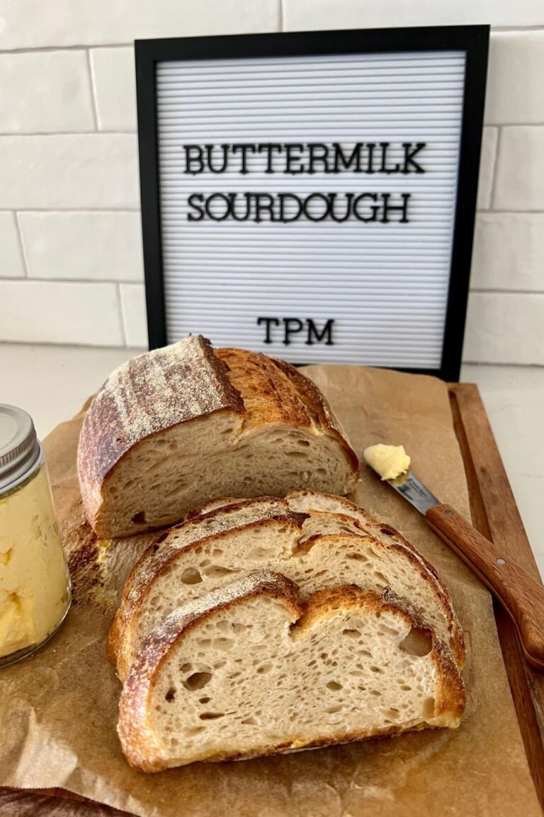 Buttermilk sourdough bread sitting on a wooden bread board