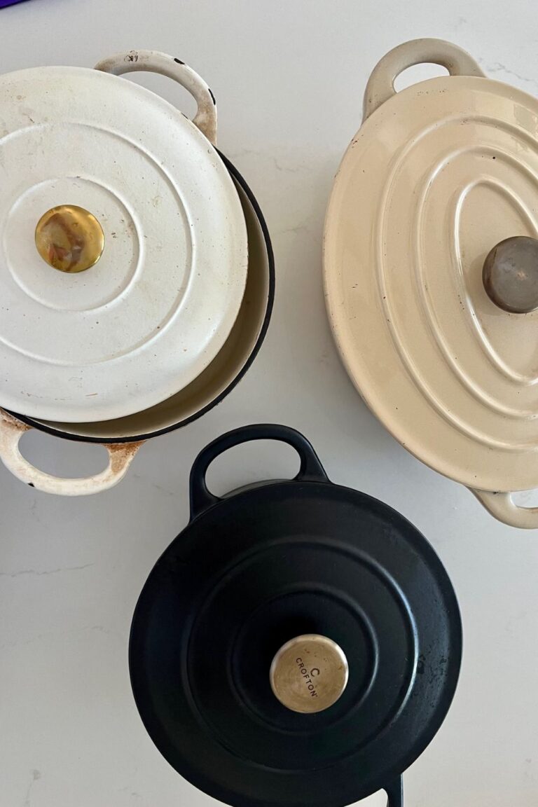 3 Dutch ovens for baking sourdough bread - a round cream enamel Dutch Oven with a brass knob, a black round enamel Dutch Oven with brass knob and a cream enamel Oval Dutch Oven, also with a brass knob.