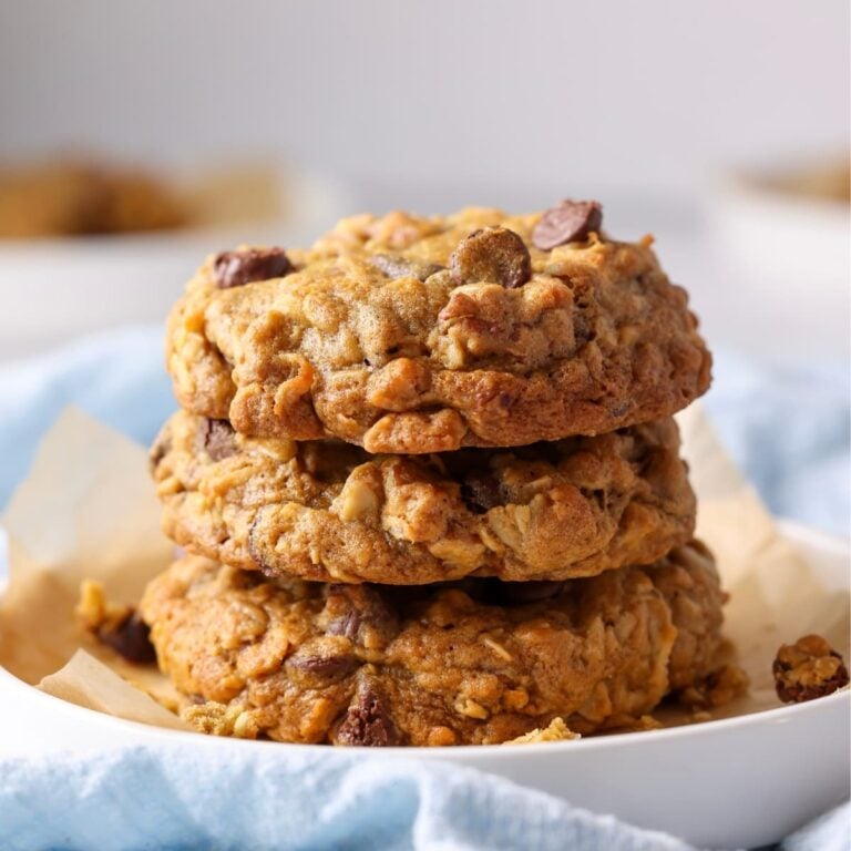 A stack of sourdough discard cowboy cookies sitting on a white plate.