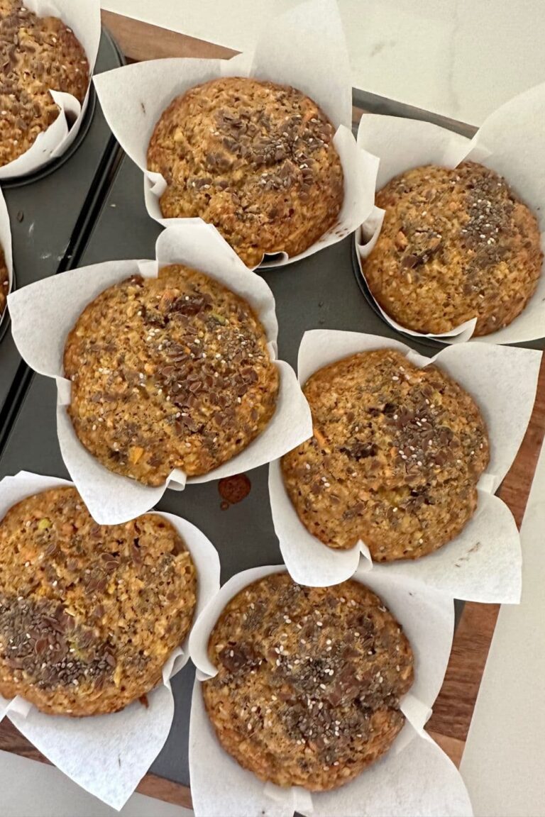 Sourdough Morning Glory Muffins in paper liners sitting in a 6 hole muffin tray.