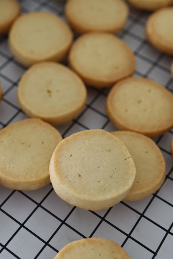 Sourdough shortbread cookies on a black wire cooling rack.