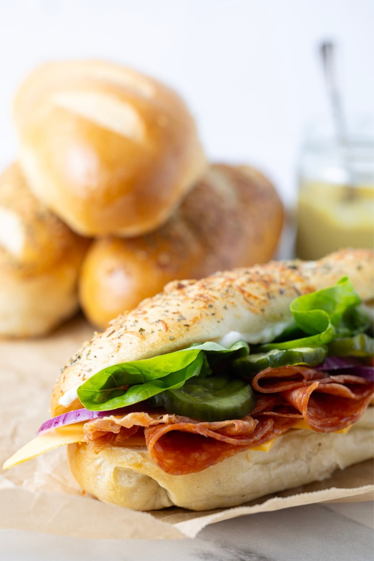 Close up of a salami and cheese sandwich on a sourdough sandwich roll.