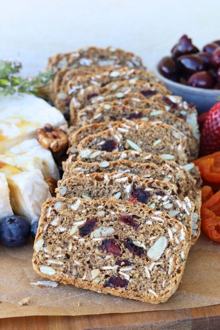 Sourdough fruit and seed crackers sitting on a cheese platter.