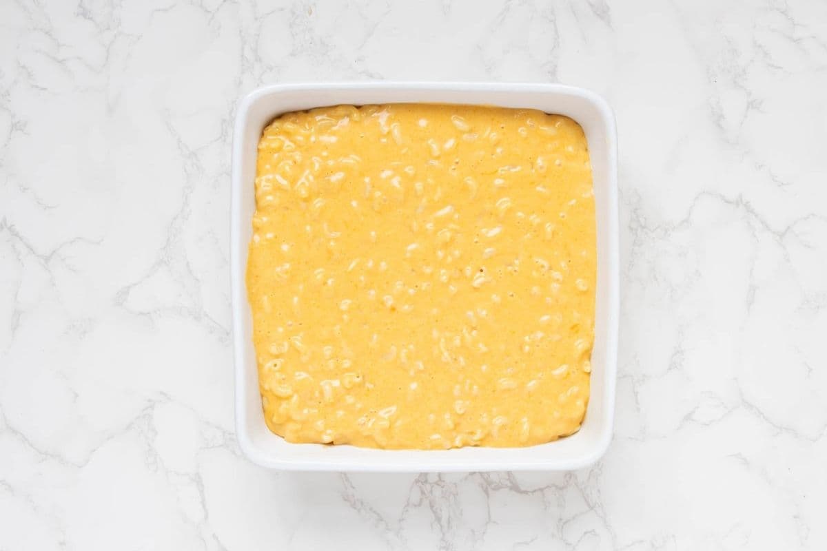 A square baking dish filled with sourdough mac and cheese before the sourdough bread crumb topping has been added.