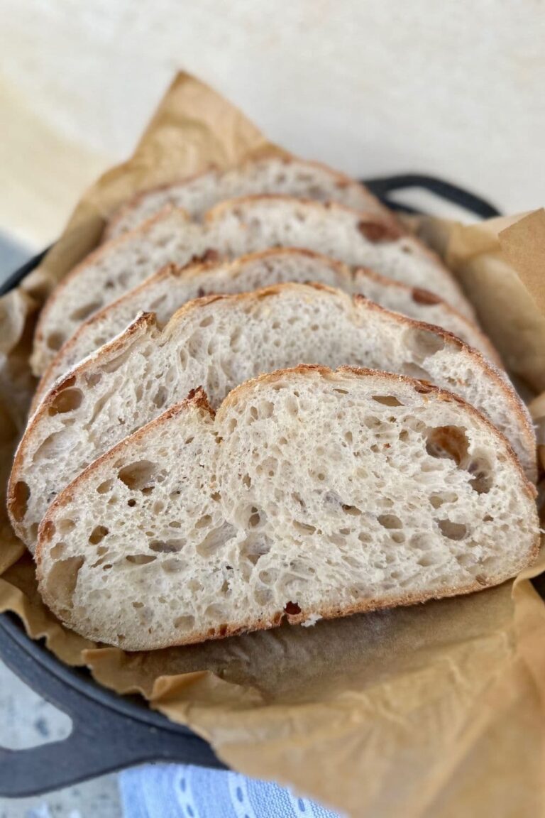 Photo showing what sourdough should look like inside - with four slices of open crumb sourdough sitting in the lid of a Lodge Cast Iron Dutch Oven.