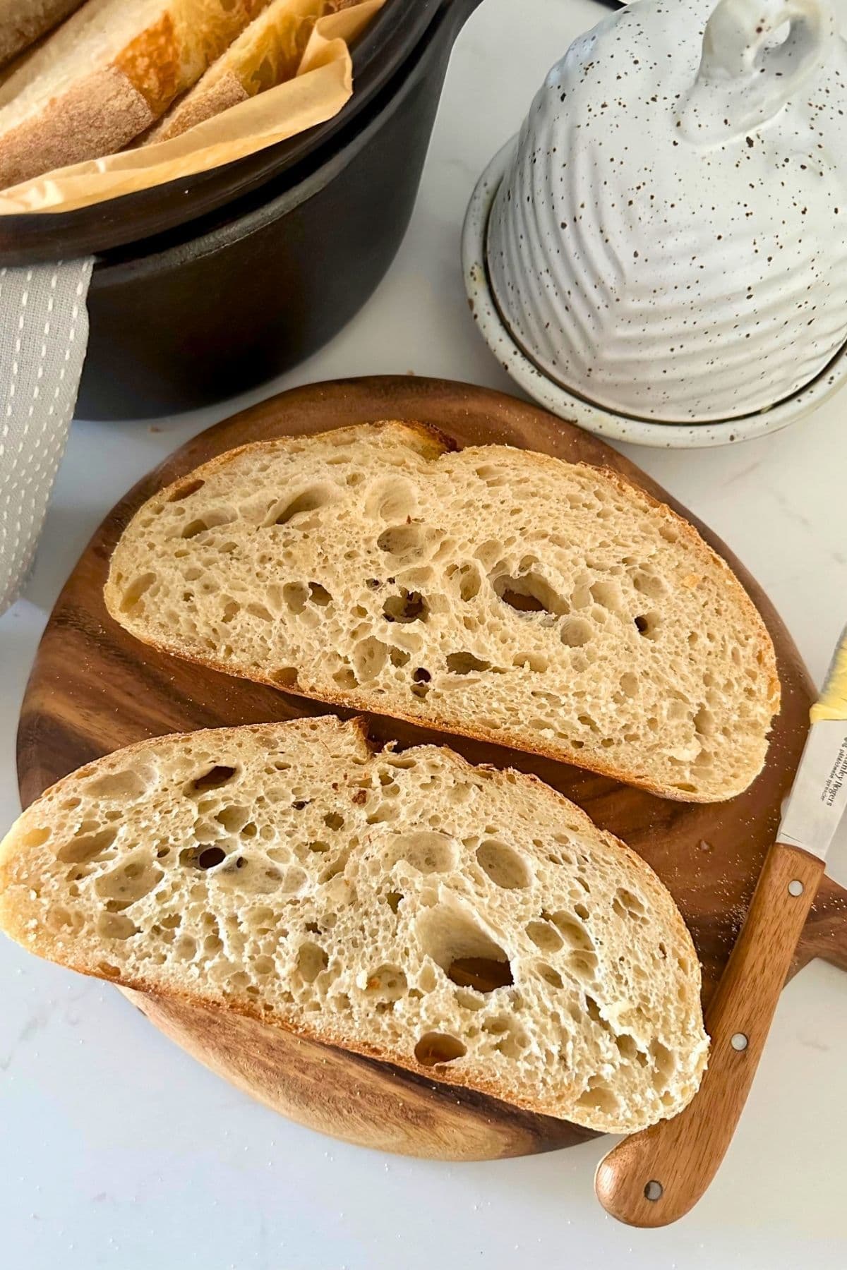 2 slices of sourdough bread on a round wooden board.