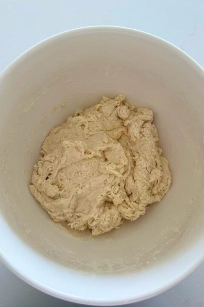 Sourdough ciabatta dough that has just been brought together into a shaggy dough and left in a bowl to hydrate.