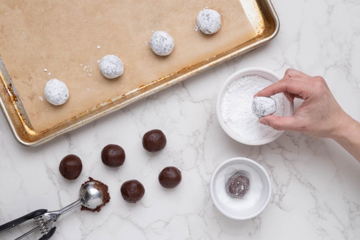 A top down photo showing the cookie dough rolled into balls and then rolled into the two different types of sugar.