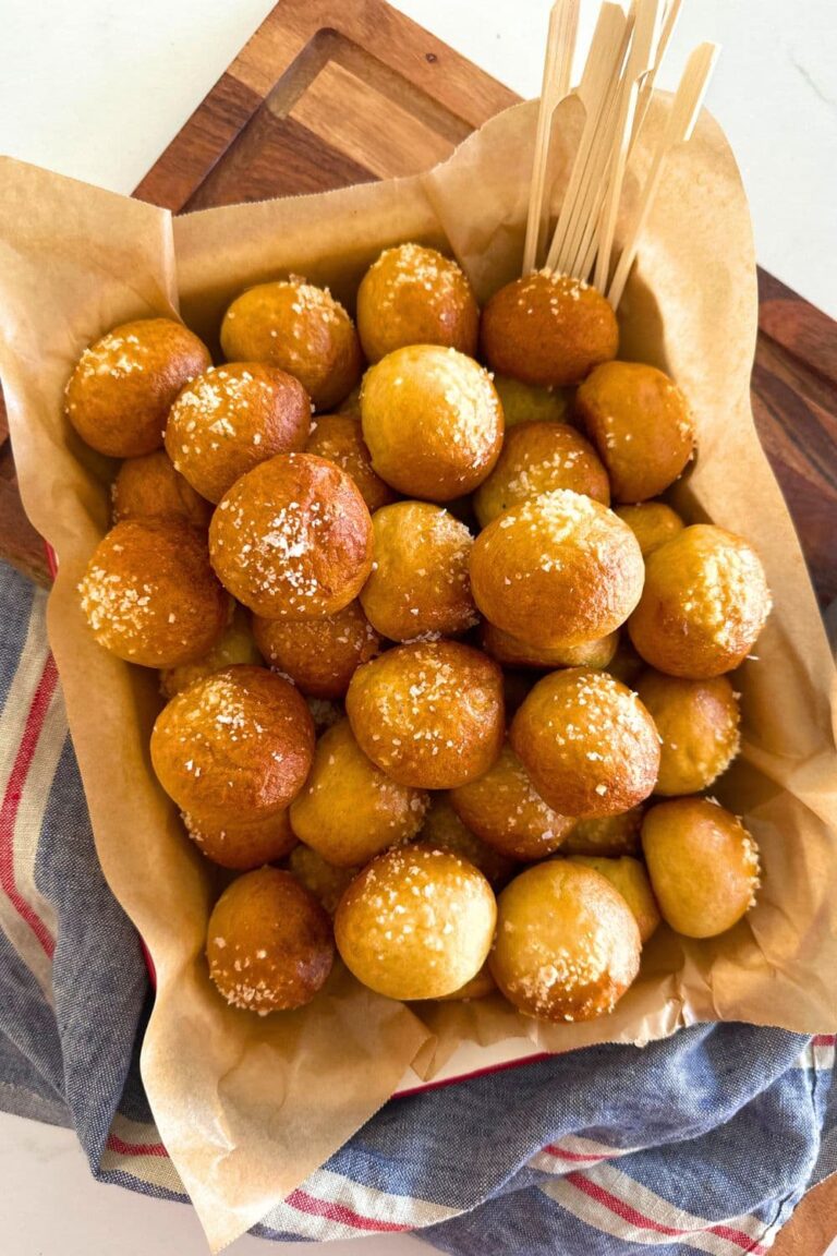 An enamel tray filled with sourdough discard pretzel bites. You can see a blue linen dish towel laying beside the tray.