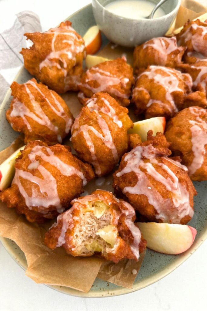 A platter of sourdough apple fritters topped with vanilla glaze.