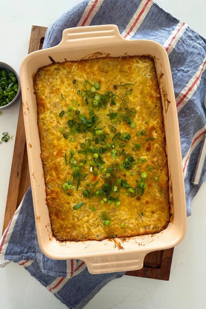 Sourdough hash brown casserole baked in a 9" x 13" baking dish and topped with green onions.