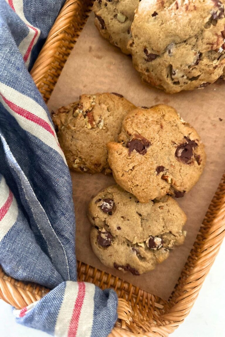 Spiced pecan sourdough cookies laid out on a rattan tray. There is a also a blue and red striped dish towel in the photo.