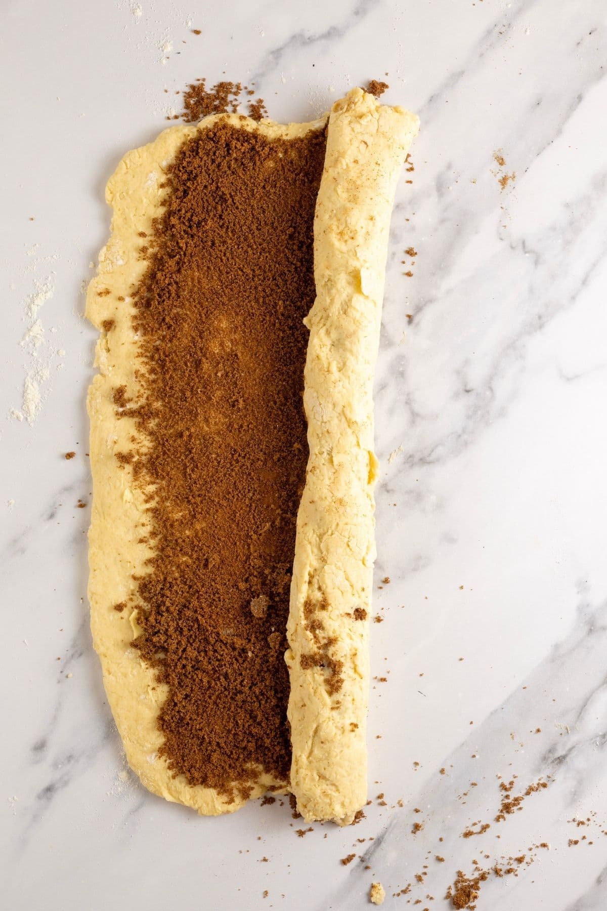 Photo showing the dough being rolled into a log from the long edge of the dough.