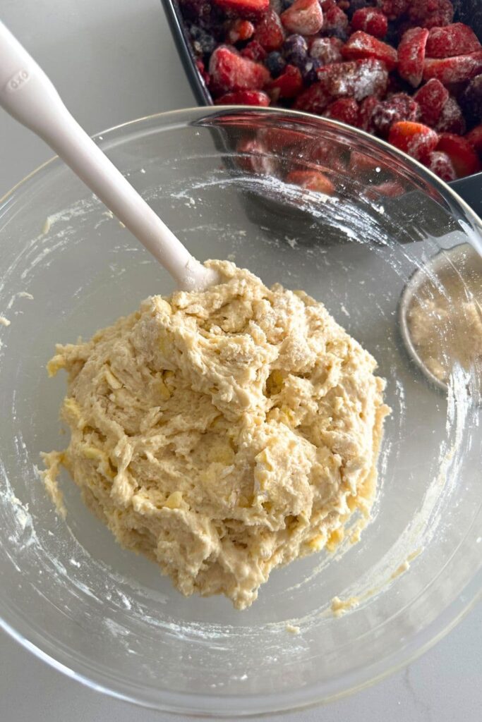 A glass bowl containing the sourdough berry cobbler topping.