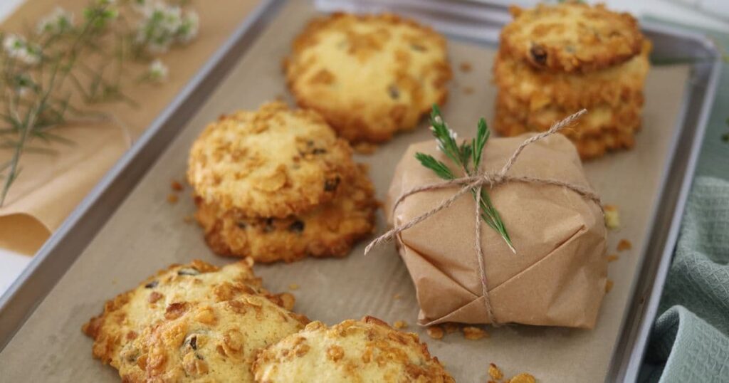 Sourdough cornflake raisin cookies displayed on a metal baking tray.