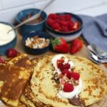 A display of sourdough discard crepes topped with nutella, whipped cream and berries.