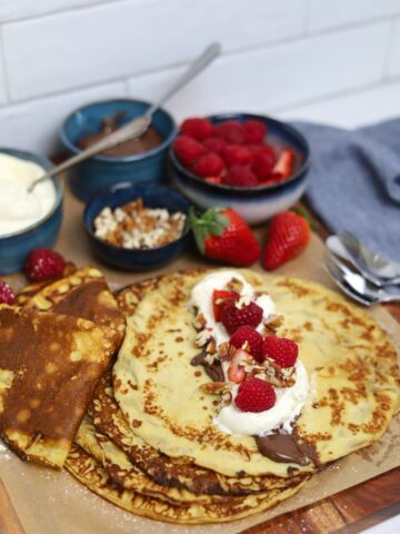 A display of sourdough discard crepes topped with nutella, whipped cream and berries.